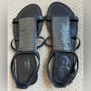 Cole Haan black leather gladiator-stylesandals with mesh embellishments.